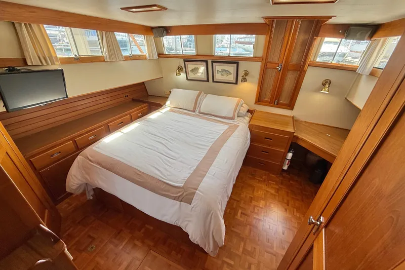 Slide: The Image of Luxurious 1992 Grand Banks 46 Classic yacht bedroom with wood accents and natural light. - 38