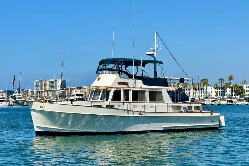 Slide: The Image of 1992 Grand Banks 46 Classic yacht on calm water, marina background. - 4