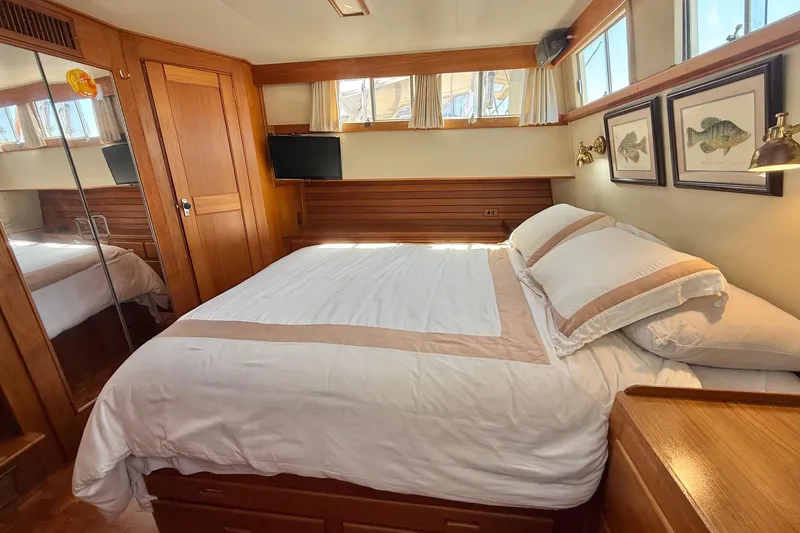 Slide: The Image of Luxurious 1992 Grand Banks 46 Classic yacht bedroom with elegant wood paneling and cozy bedding. - 46