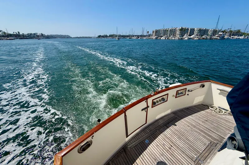 Slide: The Image of Grand Banks 46 Classic yacht cruising on a sunny day, leaving a wake behind. - 54