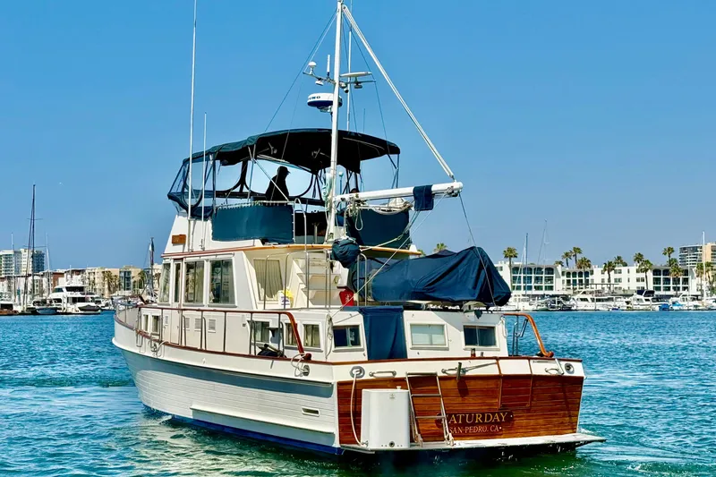 Slide: The Image of Grand Banks 46 Classic yacht from 1992 on a sunny marina backdrop. - 6