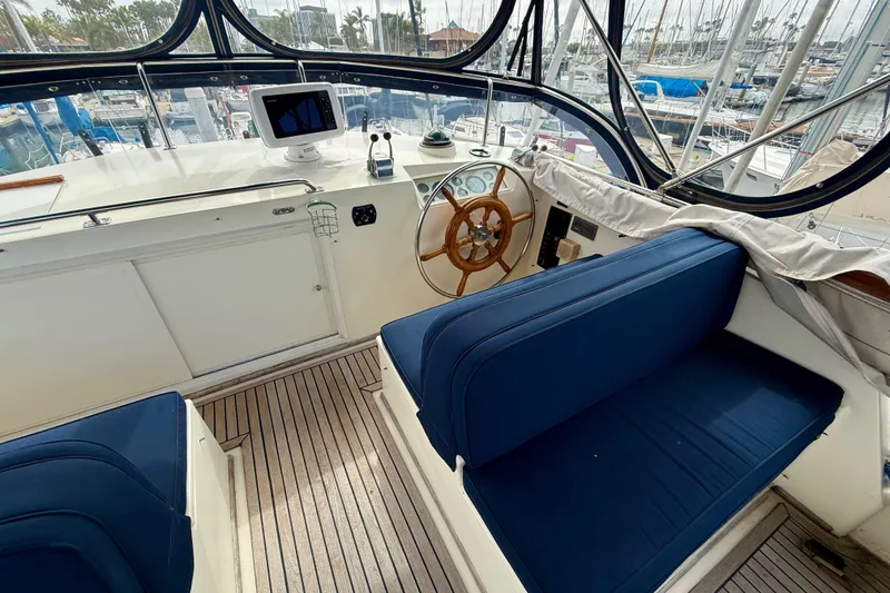 Slide: The Image of Interior of 1992 Grand Banks 46 Classic yacht with blue seating and wooden steering wheel. - 60