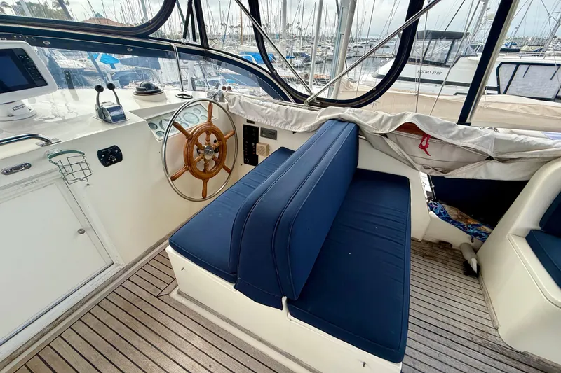Slide: The Image of Interior helm of 1992 Grand Banks 46 Classic yacht with wooden wheel and blue seating. - 64