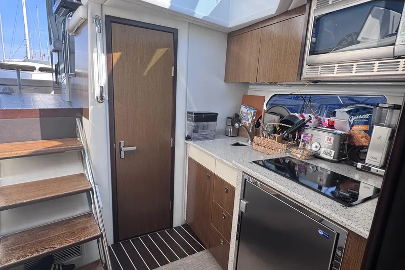 Slide: The Image of Modern kitchen interior of 2012 Cruisers Yachts 41 Cantius with appliances and wooden cabinetry. - 36