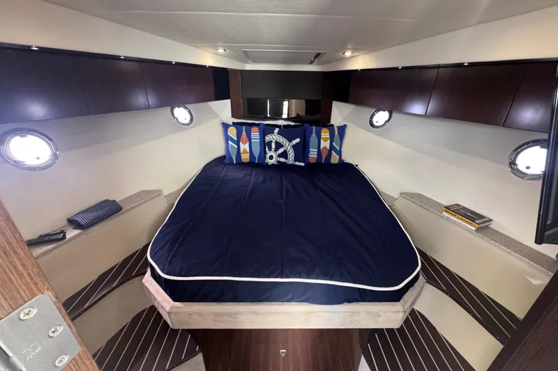 Slide: The Image of Luxurious 2012 Cruisers Yachts 41 Cantius cabin with nautical-themed bedding and porthole windows. - 39