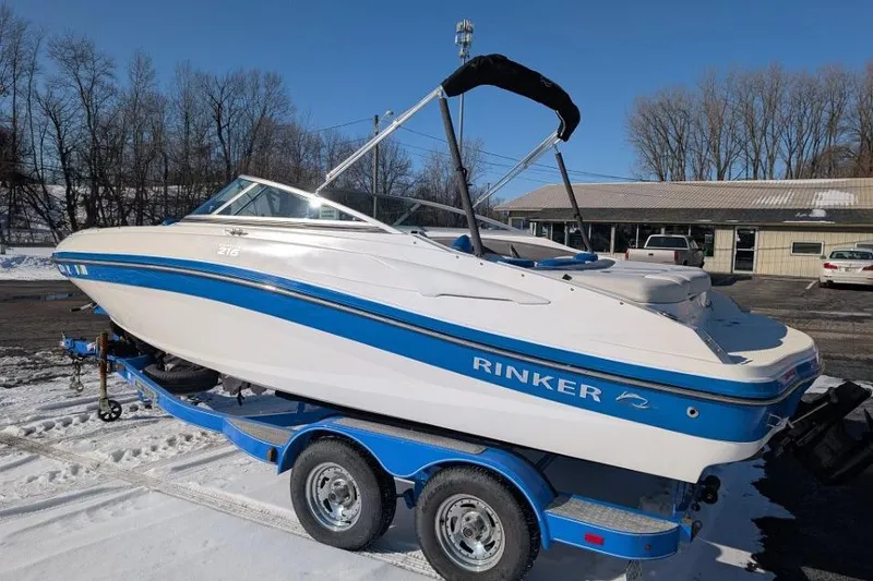 Slide: The Image of 2012 Rinker 216 Captiva Bowrider on trailer, parked in snowy outdoor setting. - 2