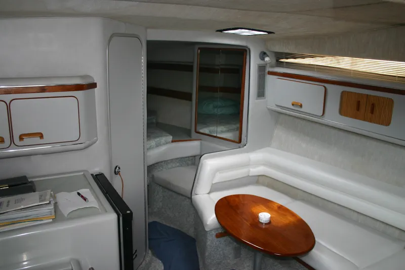 Slide: The Image of 1991 Sea Ray 310/330 Sundancer cabin interior with white seating and wooden table. - 19