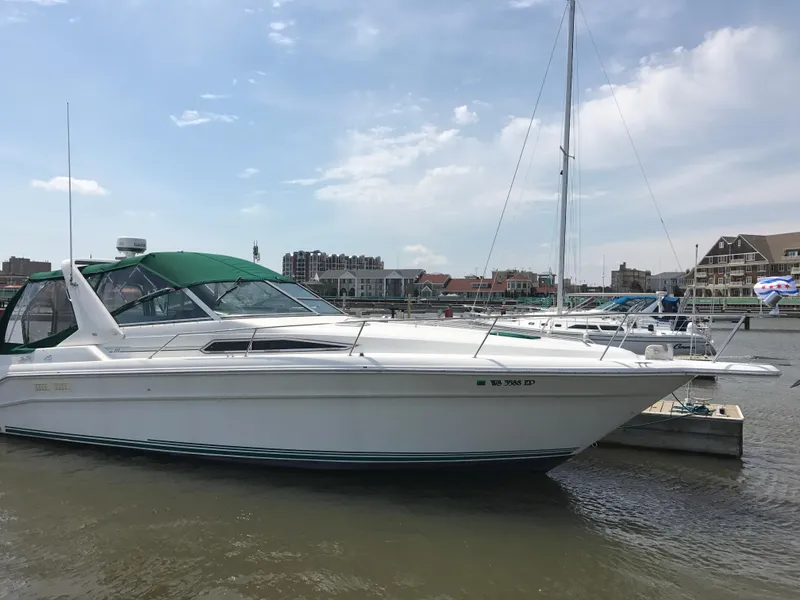 Slide: The Image of 1991 Sea Ray 310/330 Sundancer docked at marina under blue sky. - 6