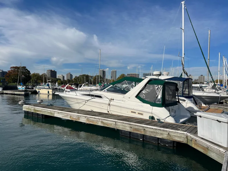 Slide: The Image of 1991 Sea Ray 310/330 Sundancer docked in a marina under a clear blue sky. - 8