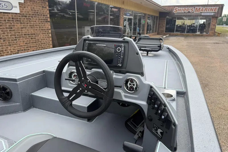 Slide: The Image of 2026 Xpress H20C Crappie boat dashboard with steering wheel and navigation controls. - 4
