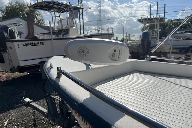 Slide: The Image of 2005 Cape Craft 16 CC boat with trolling motor, parked near other boats. - 2