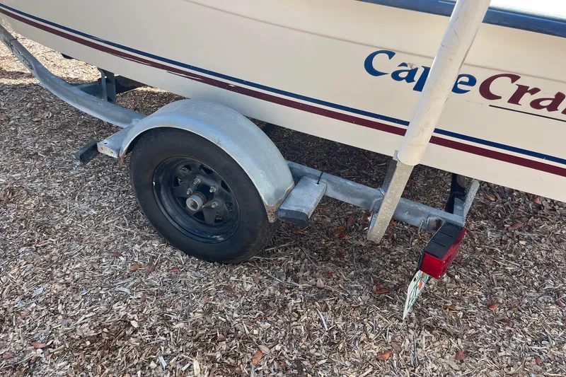 Slide: The Image of Trailer of a 2005 Cape Craft 16 CC boat on wood chips. - 3