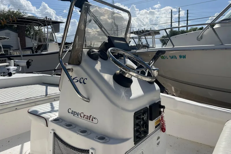 Slide: The Image of 2005 Cape Craft 16 CC boat console with steering wheel and controls, docked under a sunny sky. - 4