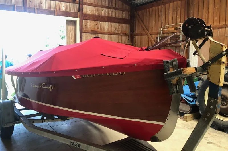 Slide: The Image of 1967 Chris-Craft 17 Deluxe boat with red cover in a barn. - 7