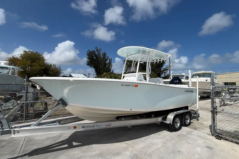 The Image of 2022 Sportsman Heritage 231 Center Console boat on trailer under blue sky. - 1