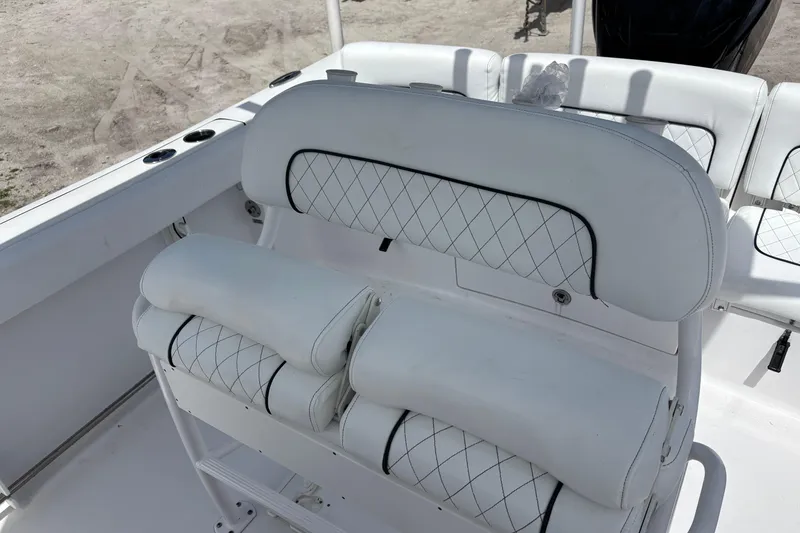 Slide: The Image of 2022 Sportsman Heritage 231 Center Console boat seating with white cushioned upholstery. - 12