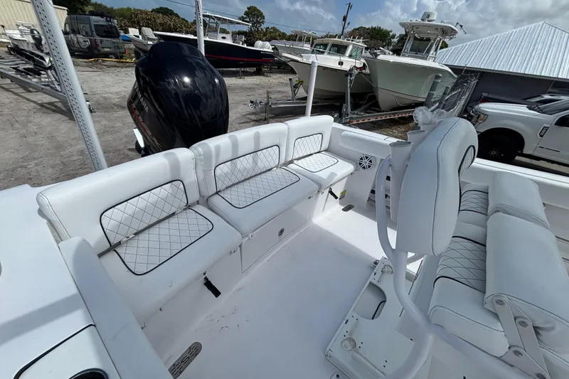 Slide: The Image of 2022 Sportsman Heritage 231 Center Console boat interior with white seating and black motor. - 4