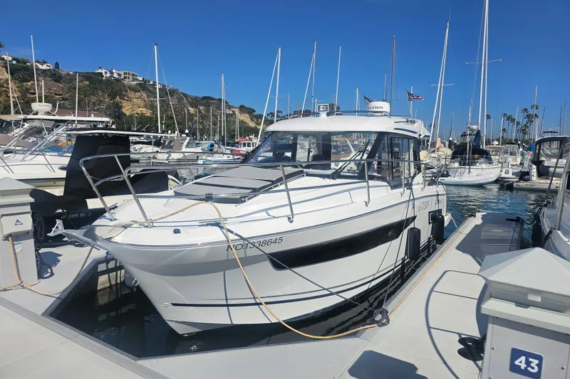 Slide: The Image of 2023 Jeanneau NC Weekender 895 docked at a marina under clear blue skies. - 2
