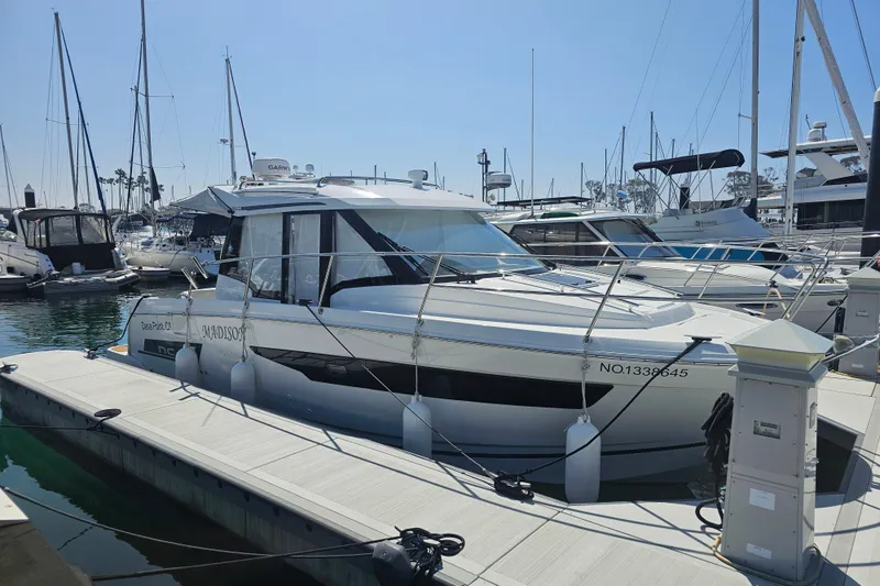 Slide: The Image of 2023 Jeanneau NC Weekender 895 docked at marina, surrounded by other boats. - 3