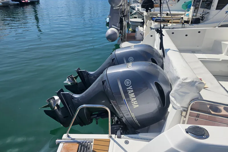 Slide: The Image of Twin Yamaha outboard engines on a 2023 Jeanneau NC Weekender 895 boat at a marina. - 6
