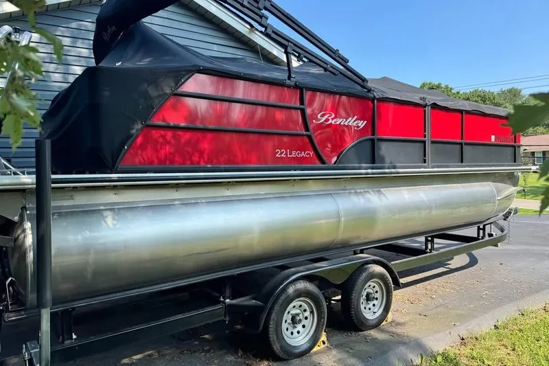 The Image of 2023 Bentley Legacy 223 SB pontoon boat on trailer, red and black design. - 0