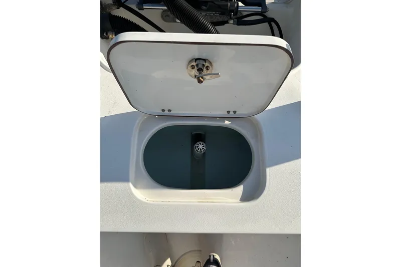 Slide: The Image of Open hatch on 2015 Sea Hunt BX 22 Pro boat, revealing storage compartment. - 13