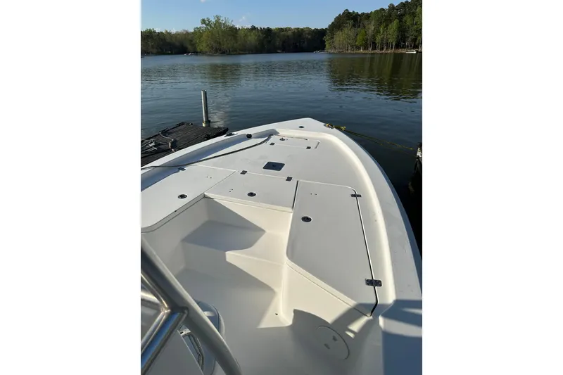 Slide: The Image of 2015 Sea Hunt BX 22 Pro boat docked on a serene lake. - 3