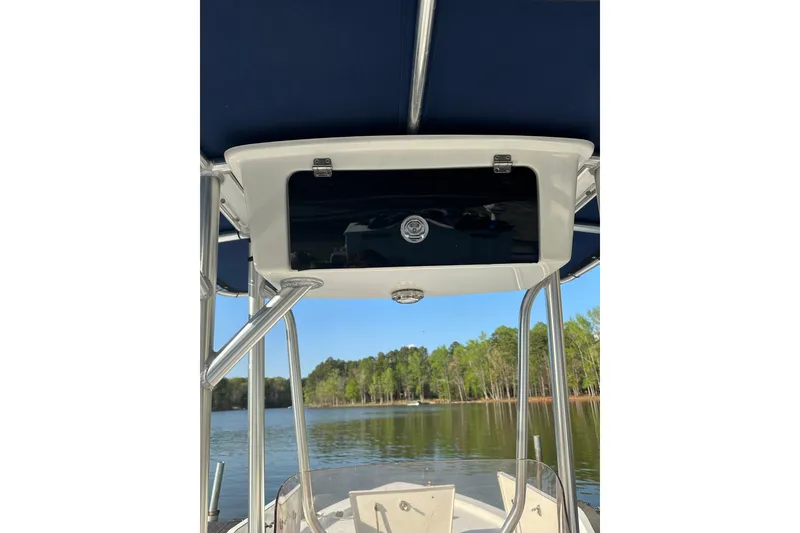 Slide: The Image of 2015 Sea Hunt BX 22 Pro boat on a serene lake with lush green trees. - 5