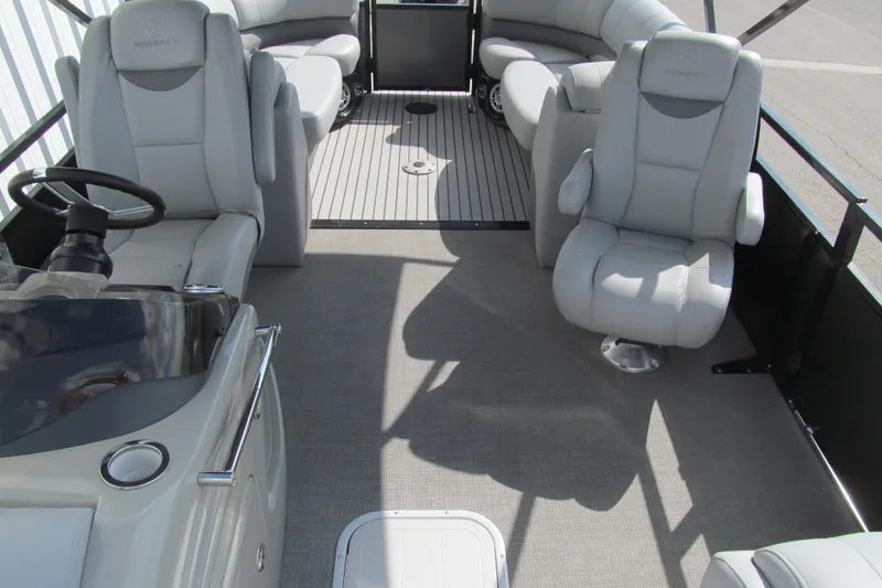 Slide: The Image of 2017 Regency 220 LE3 pontoon boat interior with plush seating and steering console. - 11