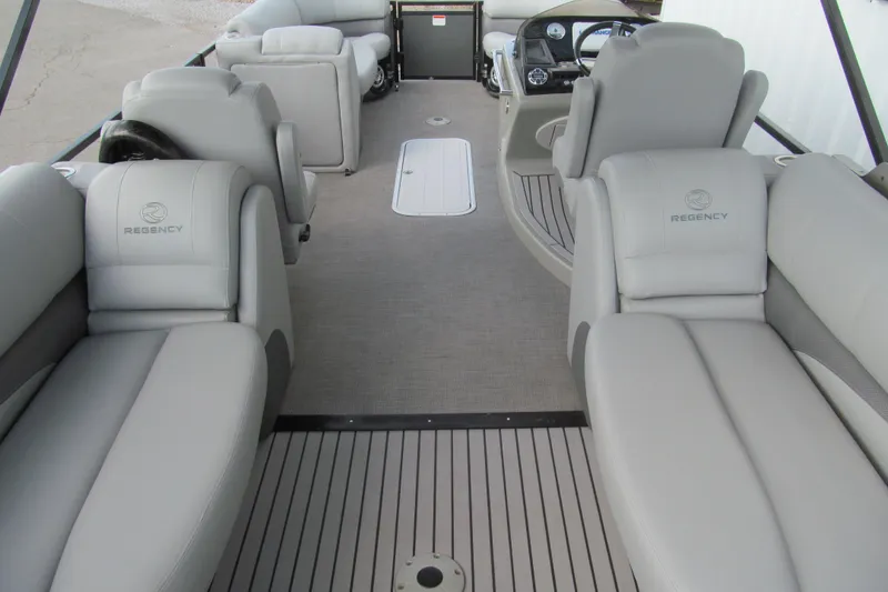Slide: The Image of 2017 Regency 220 LE3 pontoon boat interior with plush seating and modern dashboard. - 7