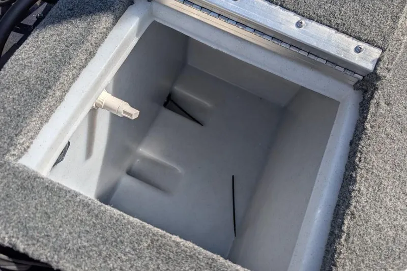 Slide: The Image of Livewell compartment in 2026 Starcraft Superfisherman 186 boat, featuring carpeted edges and drain plug. - 30
