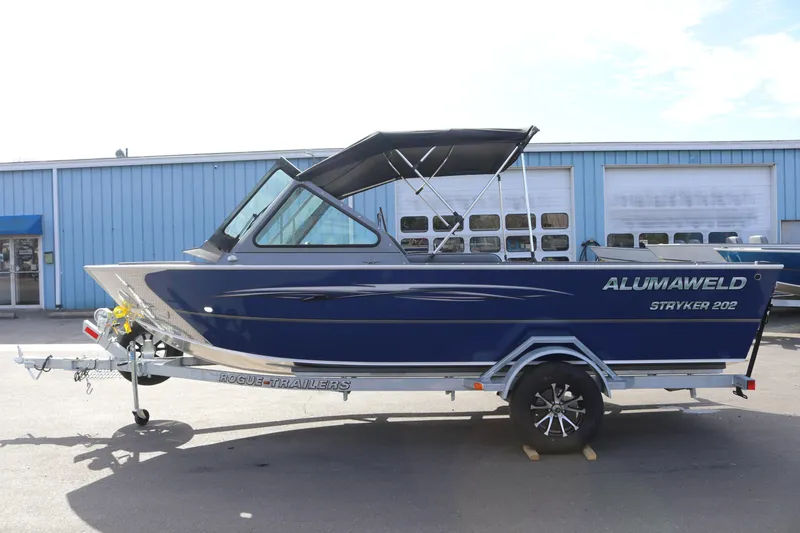 Slide: The Image of 2026 Alumaweld Stryker 202 boat on trailer, parked outside a blue building. - 31