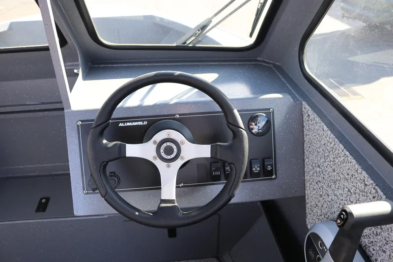 Slide: The Image of 2026 Alumaweld Stryker 202 boat dashboard with steering wheel and controls. - 6