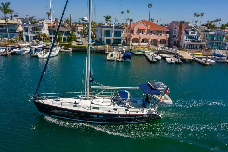 The Image of 2003 Beneteau 411 sailboat named "True Blue" on calm waters, with cityscape background. - 0