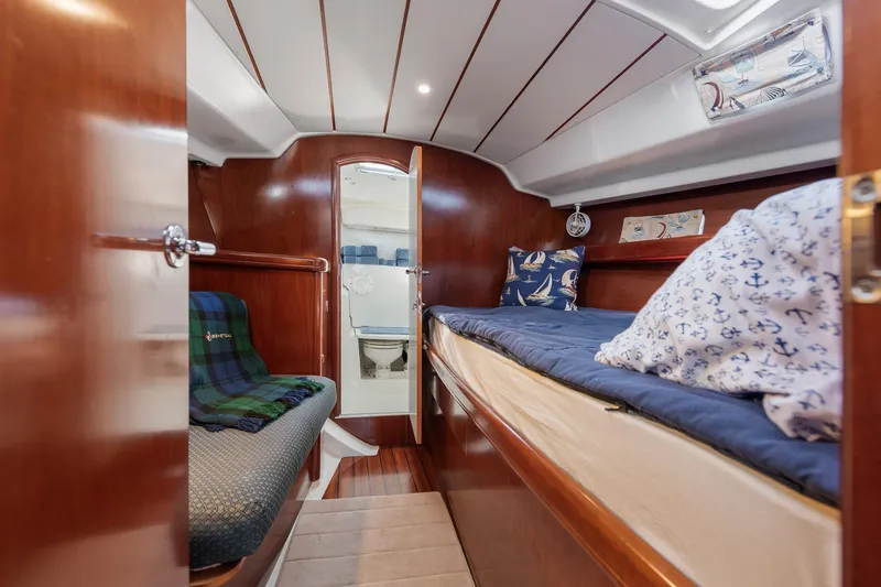 Slide: The Image of Interior of 2003 Beneteau 411 yacht, featuring cozy wooden cabin and comfortable seating. - 12