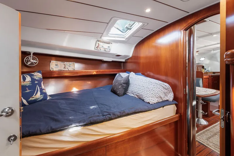 Slide: The Image of Cozy cabin interior of 2003 Beneteau 411 sailboat with wooden finish and blue mattress. - 14