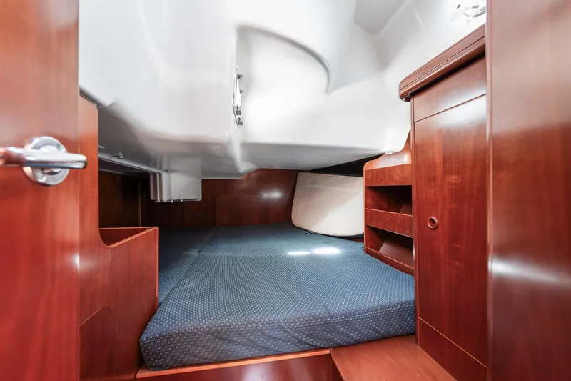 Slide: The Image of Interior cabin of 2003 Beneteau 411 sailboat with wood paneling and blue carpet. - 15