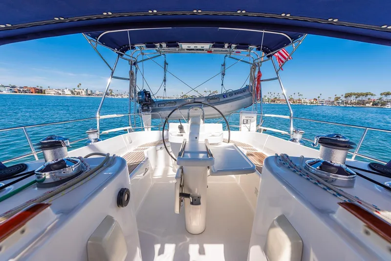 Slide: The Image of 2003 Beneteau 411 sailboat with dinghy on davits, ocean view in background. - 27
