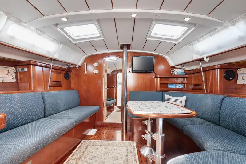 Slide: The Image of Interior of a 2003 Beneteau 411 yacht with elegant wood finish and cozy seating. - 3