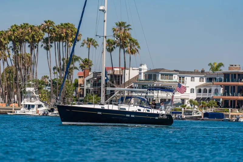 Slide: The Image of 2003 Beneteau 411 sailboat on calm water with city skyline in background. - 35