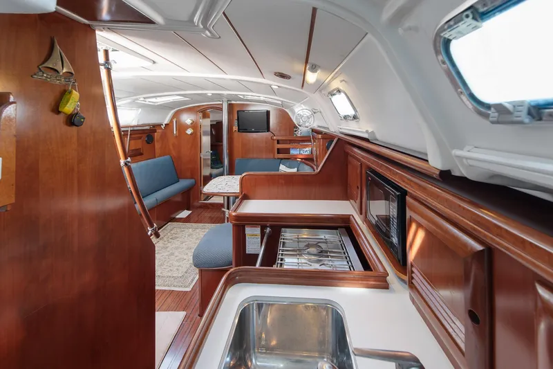Slide: The Image of Interior view of 2003 Beneteau 411 yacht kitchen with wooden cabinetry and stainless steel sink. - 6