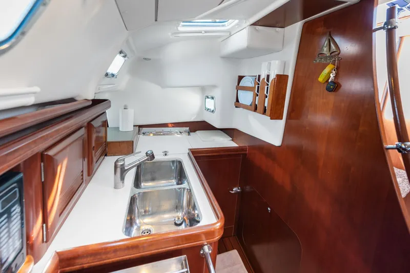 Slide: The Image of Interior of 2003 Beneteau 411 yacht, featuring cozy seating and elegant wood finishes. - 7