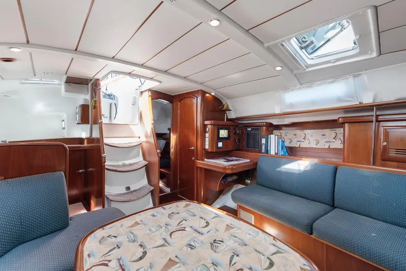 Slide: The Image of Interior of 2003 Beneteau 411 yacht with wooden finish and blue seating. - 8