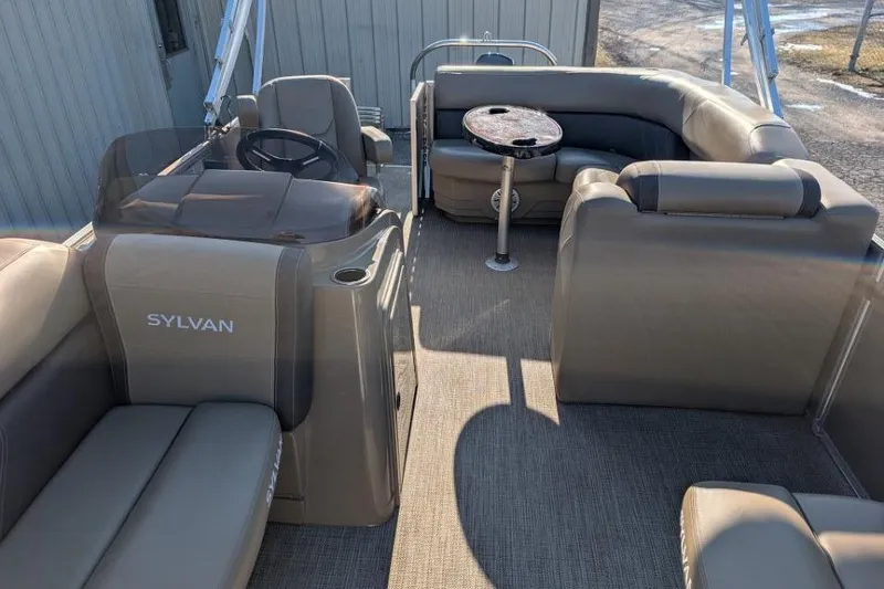 Slide: The Image of 2023 Sylvan Mirage 818 Cruise pontoon boat interior with plush seating and steering console. - 8