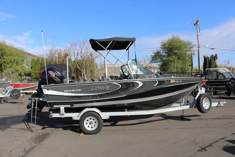 The Image of 2017 Lowe Fish & Ski 175 boat on trailer, parked outdoors under clear sky. - 1
