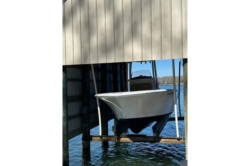 The Image of 2022 Sportsman Open 212 Center Console boat docked in a covered marina. - 0