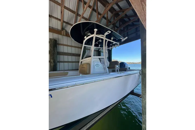 Slide: The Image of 2022 Sportsman Open 212 Center Console boat docked in a covered marina. - 1