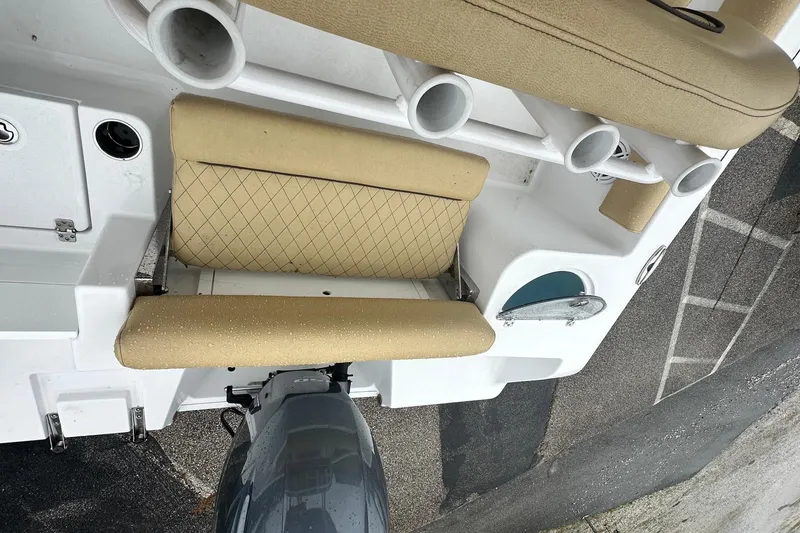 Slide: The Image of 2022 Sportsman Open 212 Center Console boat interior with beige seating and rod holders. - 18