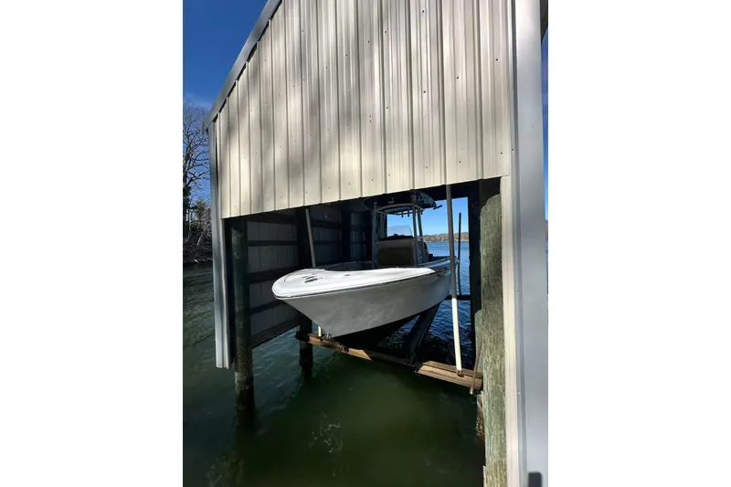 Slide: The Image of 2022 Sportsman Open 212 Center Console boat docked in a covered boathouse. - 2