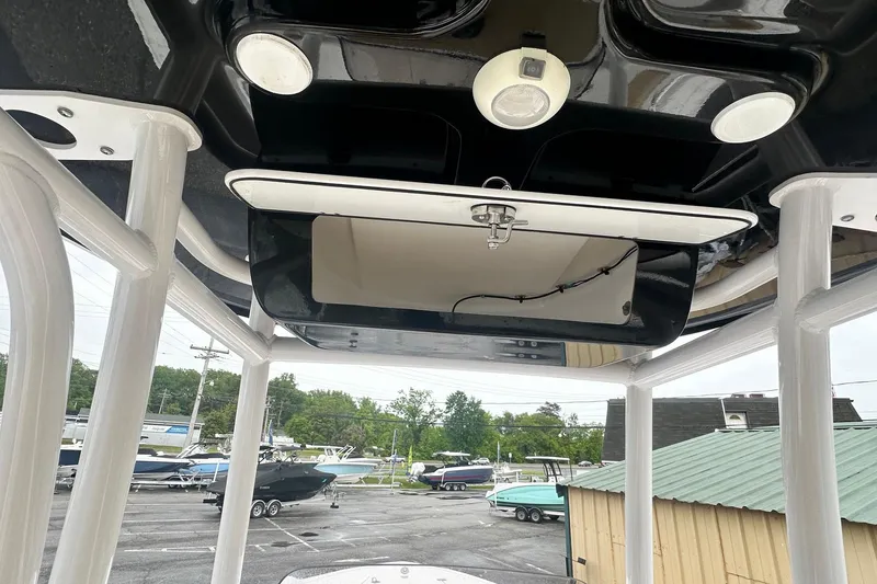 Slide: The Image of 2022 Sportsman Open 212 Center Console boat interior, featuring overhead storage and lighting. - 21